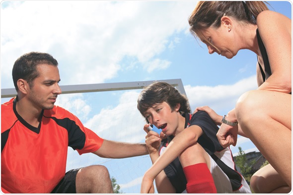 Child playing sport having an asthma attack